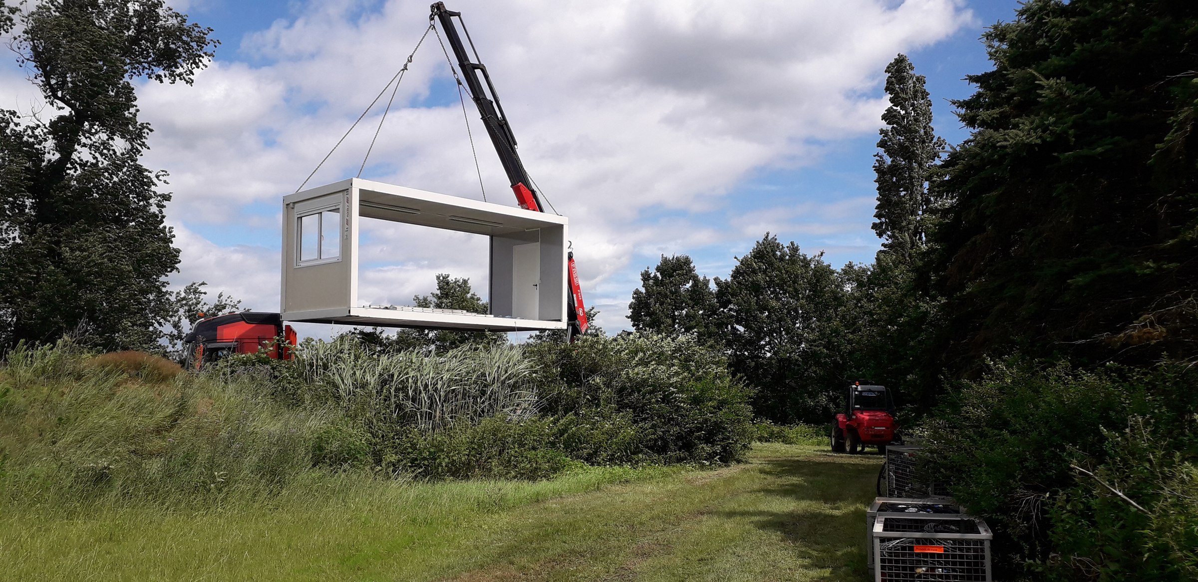 A unit being placed in the meadow by crane