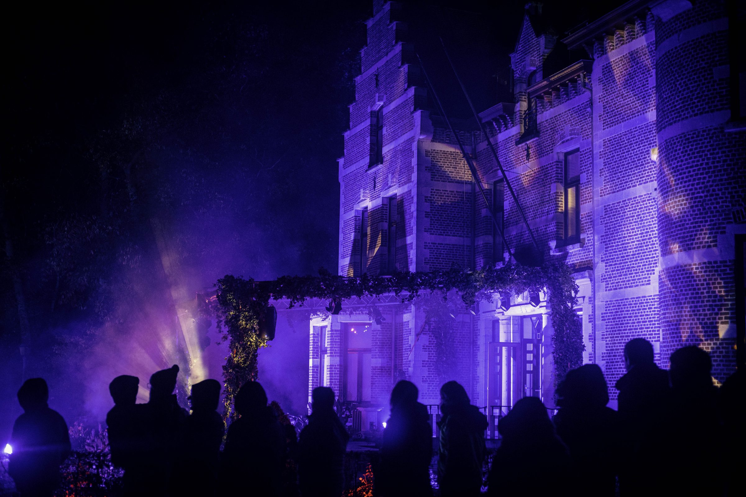 Visitors passing the lit castle