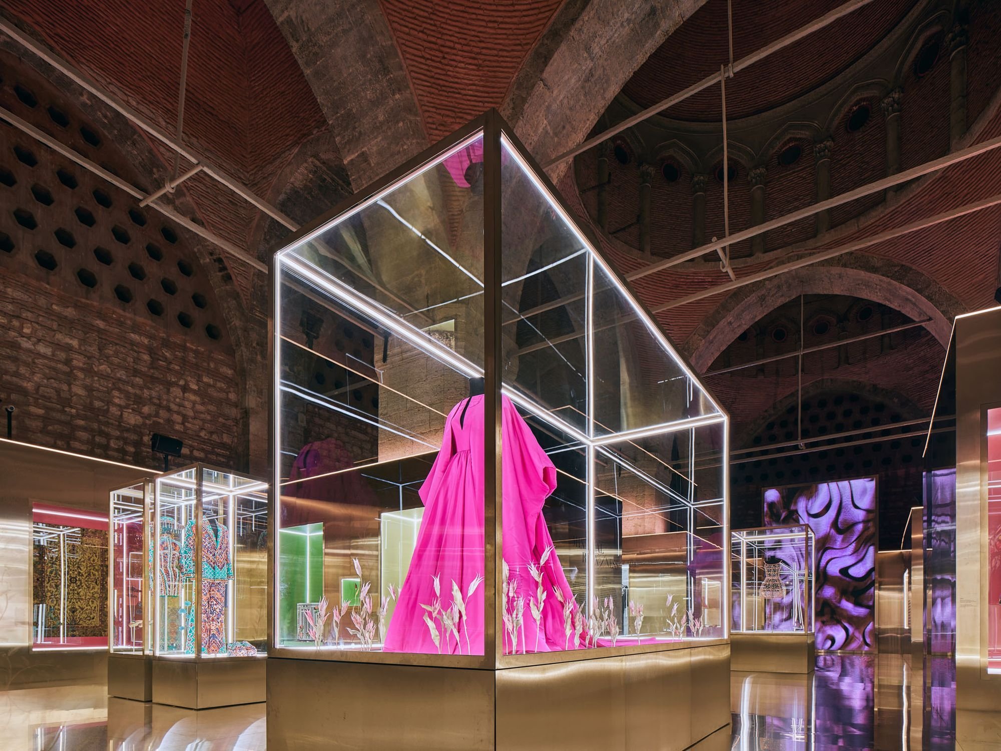 Lit display case with a gown beneath the vaults