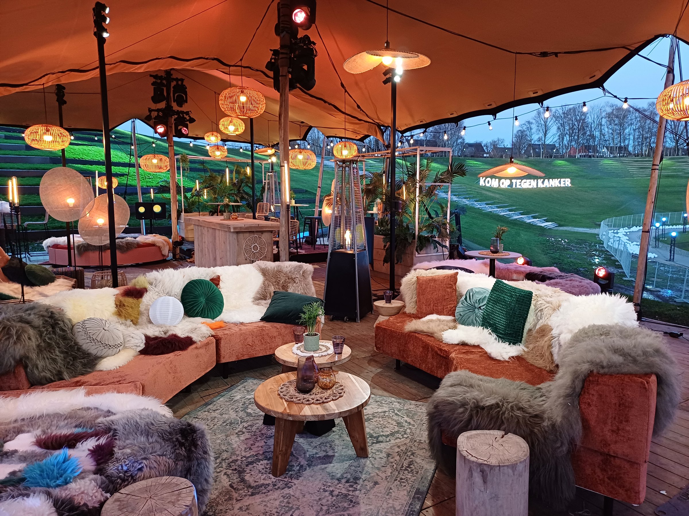 Lichtpuntjes tegen kanker: lounge set under the stretch tent at dusk
